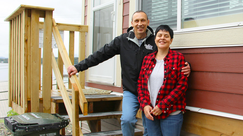 Owners of Bella Guest Cabins standing outside of cabin